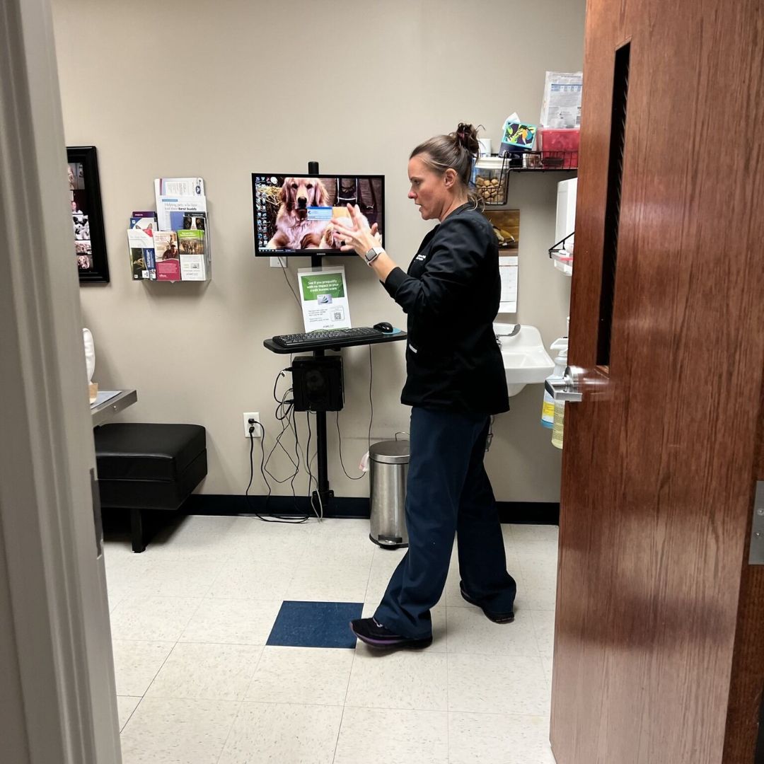 a woman standing in front of a laptop computer